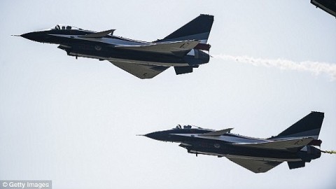 Two armed Chinese jet fighters 'nearly cause a collision' while buzzing a US Navy spy plane over the East China Sea, with one flying just 300 feet away