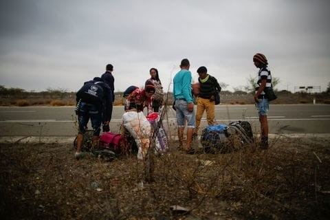 Venezuelan migrants stand along a roadside after leaving a migrant care center in Tumbes, Peru, near the border with Ecuador, on Nov. 1. Only Venezuelan citizens who entered Peru by Oct. 31 were eligible to obtain temporary residence permits. (Juan Vita/AFP)