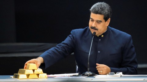 Venezuelan President Nicolás Maduro touches a gold bar as he speaks with economic officials at Miraflores Palace in Caracas in March. Photo: Marco Bello/Reuters