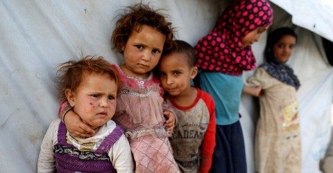 Children stand next to a tent at a camp for people displaced by the war near Sanaa, Yemen. Photo: Khaled Abdullah / Reuters