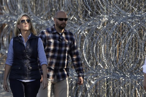Secretary of Homeland Security Kirstjen Nielsen walks next to a section of the border wall fortified with razor wire. Photo: Gregory Bull/AP