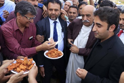 Pakistani journalist Shakil Anjum (l.) sells food with his jobless colleagues to opposition leader Bilawal Bhutto (r.) outside Parliament in Islamabad, Oct. 30.  Photo: AP