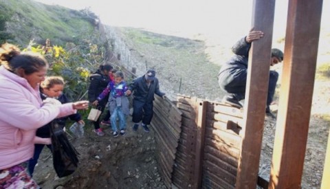 Migrantes saltan una pequeña valla en la frontera de México