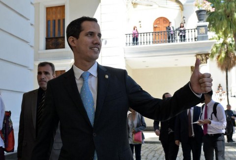 The president of Venezuela's opposition-led National Assembly, Juan Guaido, gives his thumb up as he arrives at the Federal Legislative Palace in Caracas to preside over a session to denounce President Nicolas Maduro's second mandate as 