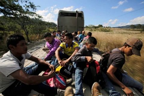 Hondurans, part of a new caravan of migrants traveling toward the United States, ride in a trailer as they hitch a ride in Cucuyagua, Honduras, Tuesday. Photo: Reuters