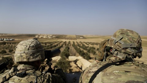 American troops look out toward the border with Turkey from a small outpost near the town of Manbij, Syria, Feb. 7, 2018. AP file photo