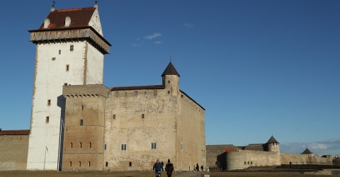 Visitors walk on the grounds of Narva's Hermann Castle, which is separated from 