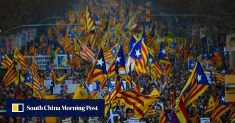 Demonstrators hold portraits of jailed Catalan separatists and wave Catalan pro-independence Estelada flags during a protest against the trial of former Catalan separatist leaders in Barcelona 
