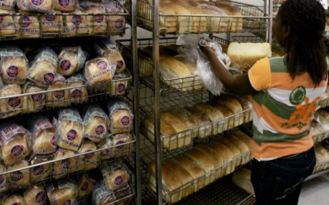 A worker arranges bread for sale inside a supermarket in Zimbabwe's capital Harare