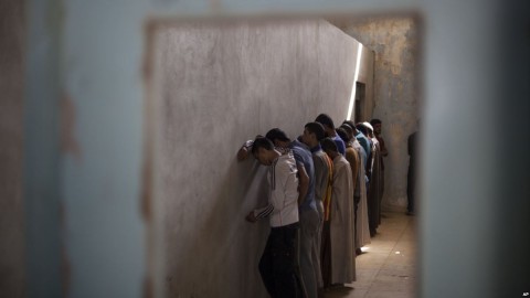 Displaced men from Hawija stand facing a wall in order not to see security officers, who will try to determine if they were associated with the Islamic State group, at a Kurdish screening center in Dibis, Iraq, Oct. 3, 2017. Photo: AP