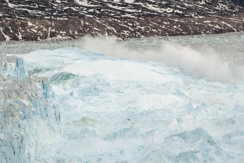 Ocean water is pushed up by the bottom of a pinnacle iceberg as it falls back during a large calving event at the Helheim glacier near Tasiilaq, Greenland, June 22, 2018. Photo: Lucas Jackson/Reuters File Photo