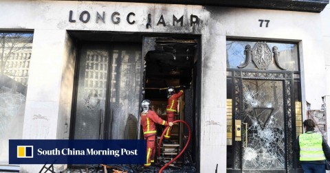 Firefighters extinguish a blaze in a Longchamp shop in Paris. 