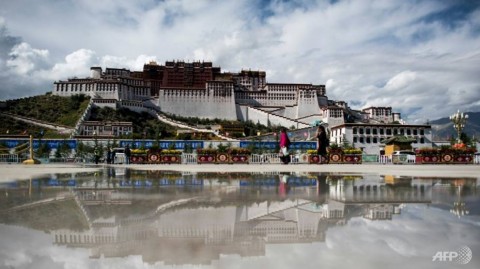 File photo of tourists walking in front of the Potala Palace in the Tibetan capital of Lhasa.