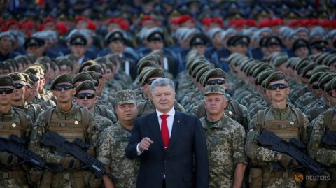 Ukrainian President Petro Poroshenko poses for a picture with servicemen during a rehearsal for the Independence Day military parade in central Kiev, Ukraine. 
