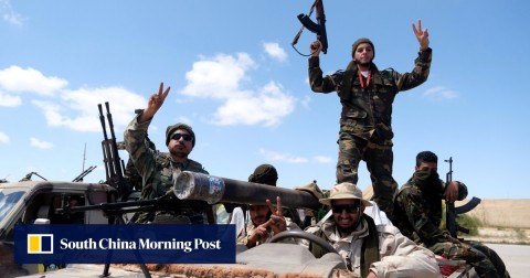 Libyan National Army (LNA) members, commanded by Khalifa Hifter, pose for a picture as they head out of Benghazi to reinforce the troops advancing to Tripoli, in Libya