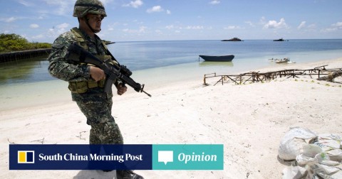 A Filipino soldier patrols on a beach on Thitu Island, which the Philippines calls Pag-asa.