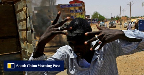 一名蘇丹抗議者跑過喀土穆的街壘。