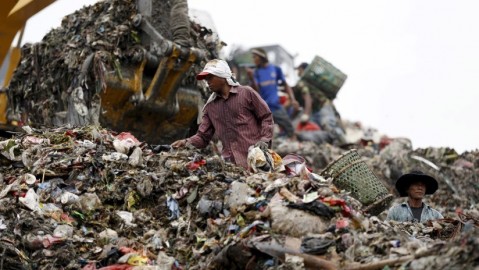 La gente busca en la basura materiales para reciclar.
