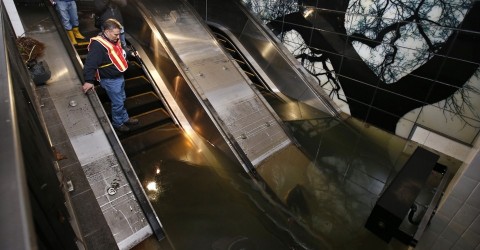 Joseph Leader, the vice president of the New York MTA, inspects a flooded escalator down to a subway platform in the days after Hurricane Sandy
