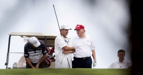 President Donald Trump talks to a caddie during a round of golf at Trump International Golf Club in West Palm Beach. Allen Eyestone/The Palm Beach Post