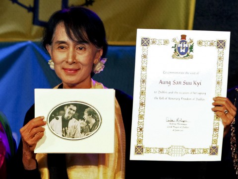 Aung San Suu Kyi holding up her Freedom of the City Awards in 2012 when she was finally able to collect the awards. Photo: Getty Images