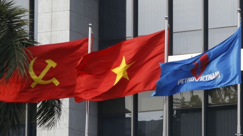 Flag of PetroVietnam flutters next to Vietnamese national flag and Communist Party flag in front of the headquarters of PetroVietnam in Hanoi Jan. 11, 2016.