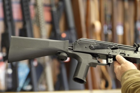 A bump stock device that fits on a semi-automatic rifle to increase the firing speed, making it similar to a fully automatic rifle, is installed on an AK-47 semi-automatic rifle at a gun store in Salt Lake City, Utah. Photo: George Frey/Getty Images