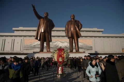 People lay flowers at the feet of statues of late North Korean leaders Kim Il-sung (l) and Kim Jong-il to mark the 6th anniversary of the death of Kim Jong-il, in Pyongyang. Photo: Kim Won-jin, AFP