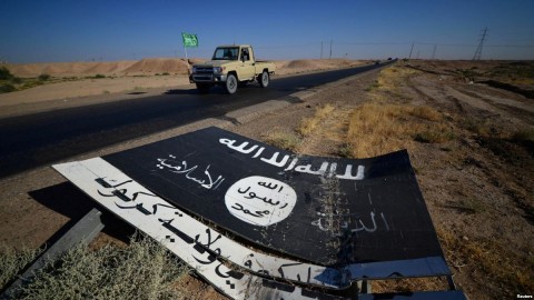 A black sign belonging to Islamic State militants is seen on the road in Al-Fateha military airport south of Hawija, Iraq, Oct. 2, 2017. Remaining IS fighters in Iraq and Syria are fleeing for parts of Syria controlled by President Bashar al-Assad.