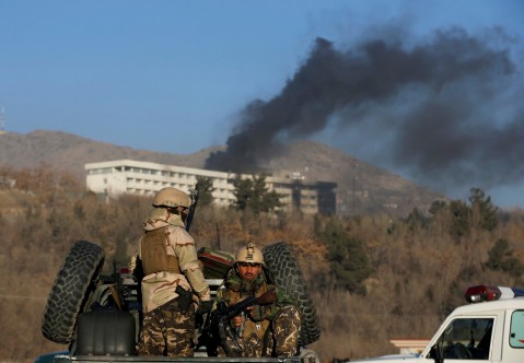 Afghan security forces keep watch Sunday as smoke rises from the Intercontinental Hotel in Kabul. (Omar Sobhani/Reuters)