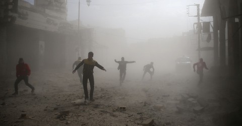 Civil defense members and civilians are seen running after an air raid in the besieged town of Douma, Syria, on February 6, 2018. Bassam Khabieh / Reuters
