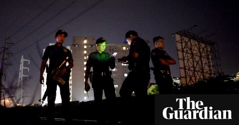 Police officers stand guard near a crime scene where a suspected drug pusher was shot dead in Manila. Photograph: ddp USA/Rex/Shutterstock