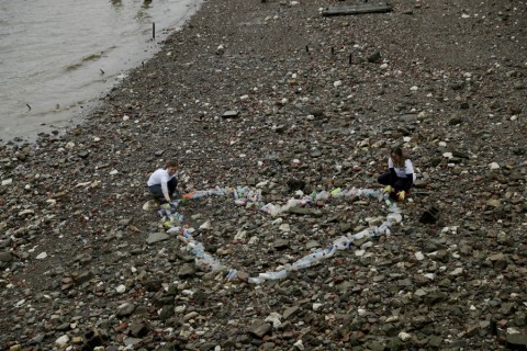 Volunteers from the #OneLess campaign and Thames21 charity assemble a heart-shaped collection of plastic bottles found in the Thames River on Feb.9, 2018, in London. Photo: Matt Dunham/AP