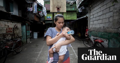 Trixia, 19, bottle feeds her four month-old daughter near her home in a deprived community in Navotas, Metro Manila, the Philippines. Photo: Hanna Adcock/Save the Children