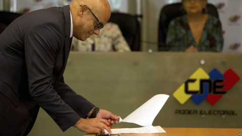 Communications Minister Jorge Rodriguez signs an agreement made with several opposition parties to delay presidential elections at the Venezuelan National Electoral Council in Caracas, Venezuela, March 1, 2018.