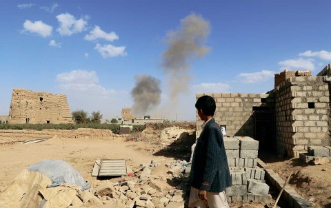 A boy looks at dust rising from the site of airstrikes in Saada, Yemen, on February 27, 2018. (Photo: Naif Rahma/Reuters)