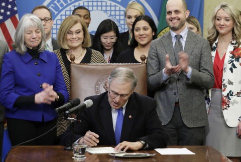 Washington Gov. Jay Inslee signs a bill March 5, 2018, that makes Washington the first state to set up its own net-neutrality requirements. Photo: AP/Ted S. Warren