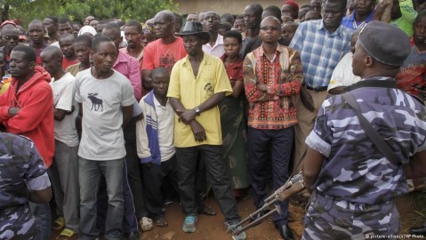 A crowd of Burundians and a soldier stand on the spot where an attack took place in early May. Photo: picture-alliance / AP