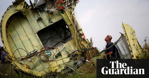  A Malaysian air crash investigator inspecting the crash site in 2014. Photo: Maxim Zmeyev/Reuters