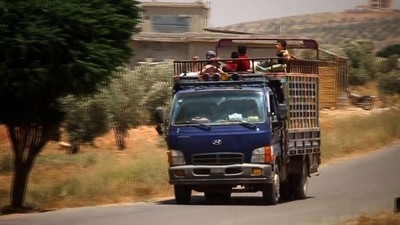 シリア政権軍のダルアー空爆、トラックで避難する人々