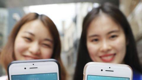 Zwei Frauen zeigen ihr Smartphone mit ihren Sozialkreditpunkten bei dem kommerziellen Anbieter Sesame Credit