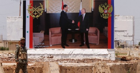 A billboard on the side of a road in Syria shows Assad and Putin shaking hands Photo: Omar Sanadiki / Reuters