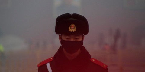 A paramilitary officer in Beijing wears a mask after a red alert was issued for heavy air pollution in 2016. Photo: Jason Lee/Reuters