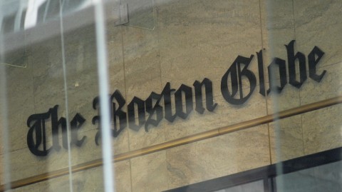 The Boston Globe's logo as seen through the windows across from the new location of the Globe in Boston. The paper's editors coordinated a campaign defending a free press in editorials. Joseph Prezioso/AFP/Getty Images