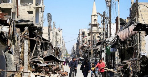 Residents walk through the Syrian city of Douma during a government-organized media tour earlier this year. Photo: Ali Hashisho / Reuters