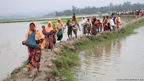 Rohingya Muslim refugees walk to the Bangladesh-Myanmar border fence. Photo: R. Asad / NurPhoto