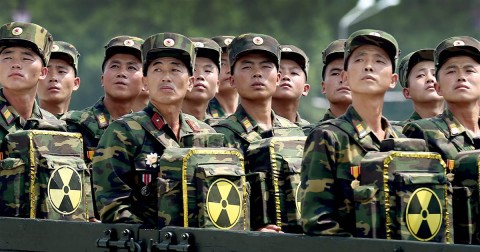 North Korean soldiers look toward leader Kim Jong Un as they carry packs marked with the nuclear symbol during a ceremony marking the 60th anniversary of the Korean War armistice in Pyongyang, North Korea on July 27, 2013. Photo: Wong Maye-E / AP