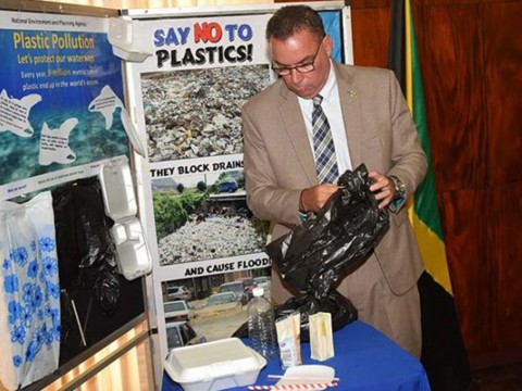Minister without Portfolio in the Ministry of Economic Growth and Job Creation, Hon. Daryl Vaz, looks at some of the plastic products that the Government will ban starting January 2019. Photo: Jamaica Information Service