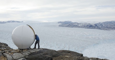 Safety officer Brian Rougeux assembles a radar dome while working at the research camp above Helheim Glacier near Tasiilaq, Greenland, on June 20, 2018. Photo: Lucas Jackson / Reuters