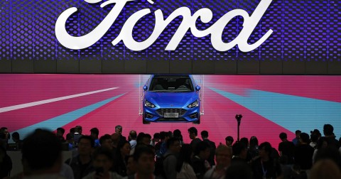 Visitors and journalists crowd near a Ford Focus on display at the Ford exhibit during media day for the China Auto Show in Beijing, April 25, 2018. Photo: Andy Wong / AP